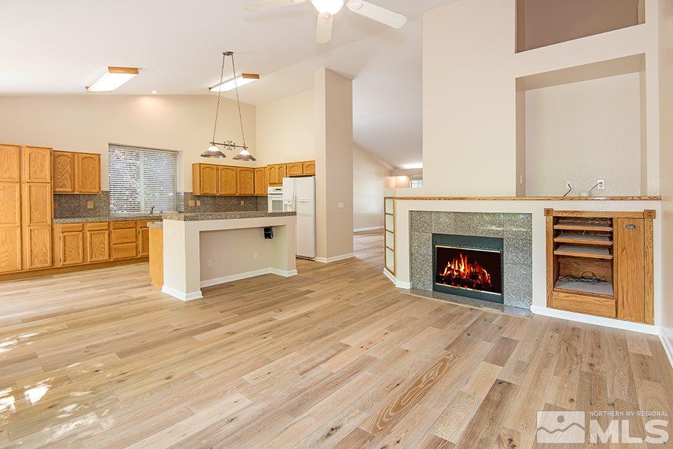 245 Falling Water Court Reno, NV 89519 - Photo 7 of 20 a open kitchen with granite countertop a stove top oven a sink and a fireplace