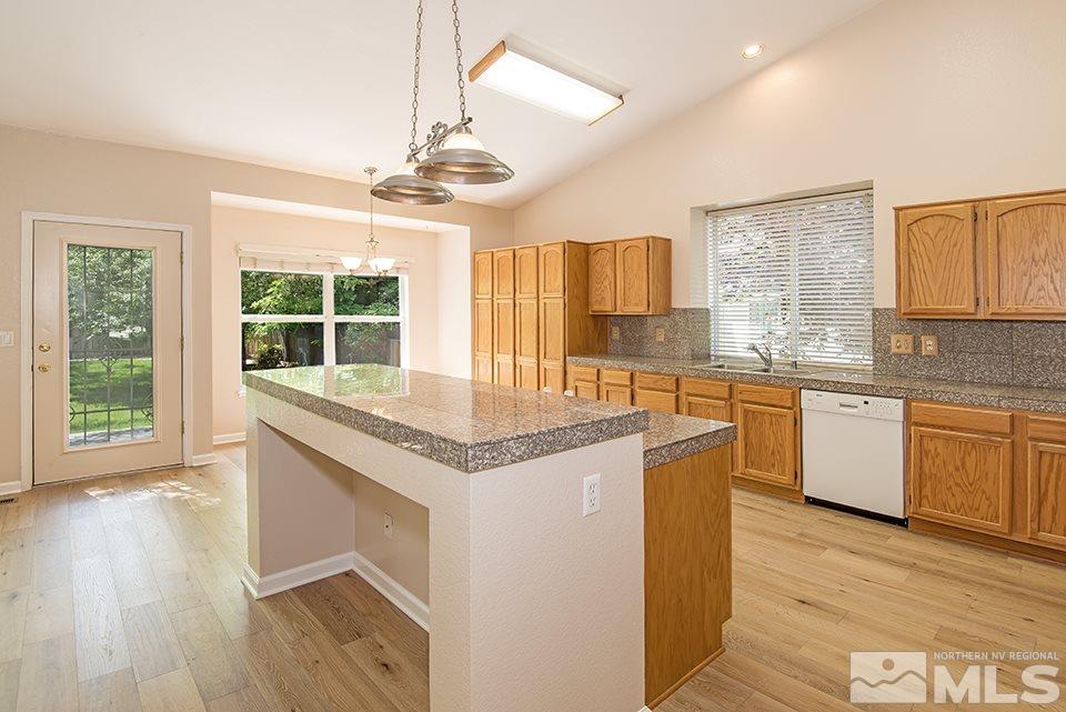 245 Falling Water Court Reno, NV 89519 - Photo 10 of 20 a kitchen with granite countertop a stove a sink a counter space wooden floor and cabinets