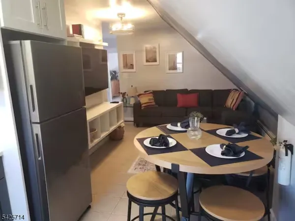 a kitchen with sink refrigerator dining table and chairs