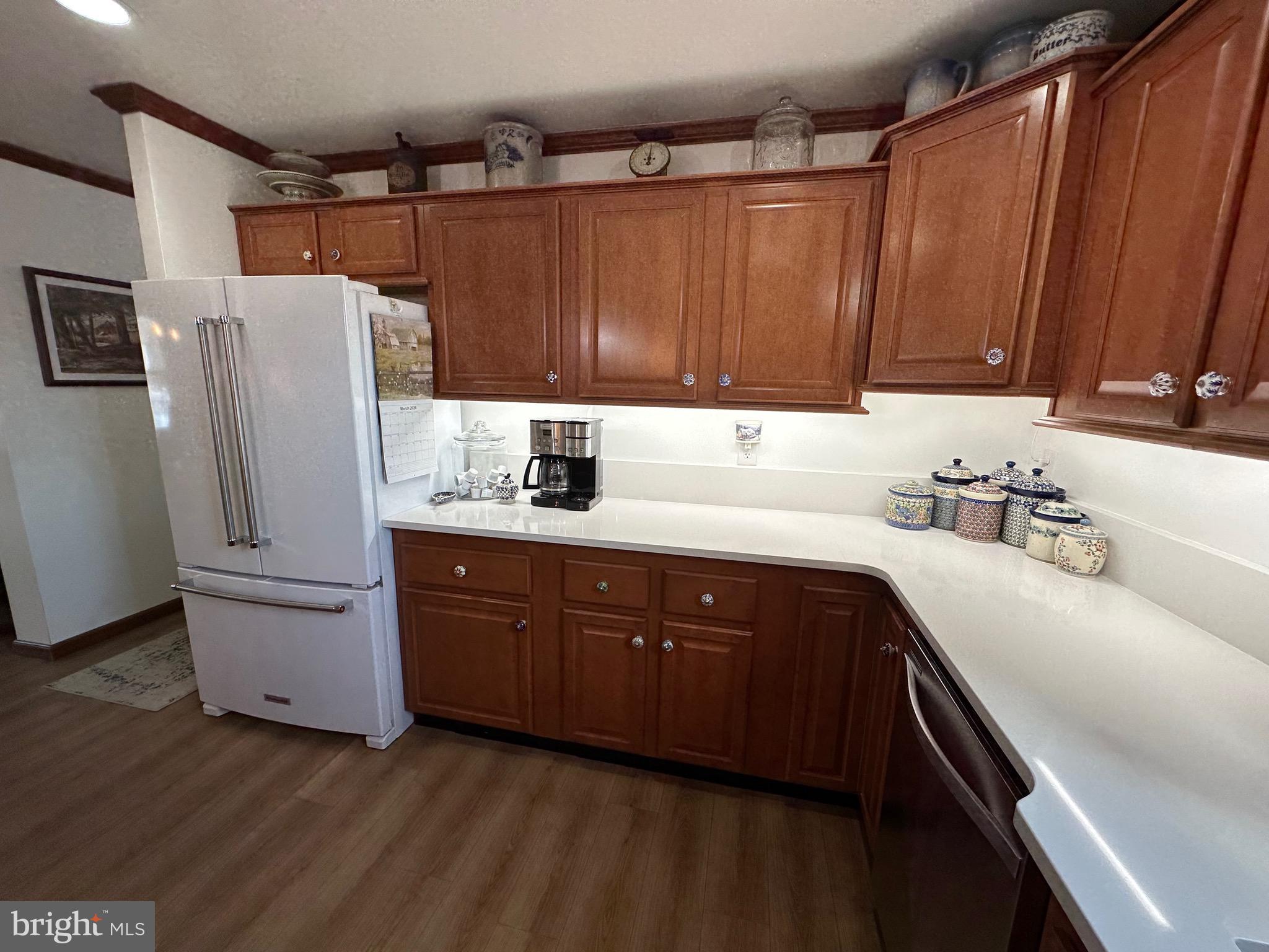 3402 Elk Lick Road Everett, PA 15537 - Photo 16 of 80 a kitchen with stainless steel appliances granite countertop a refrigerator a sink dishwasher and wooden cabinets with wooden floor