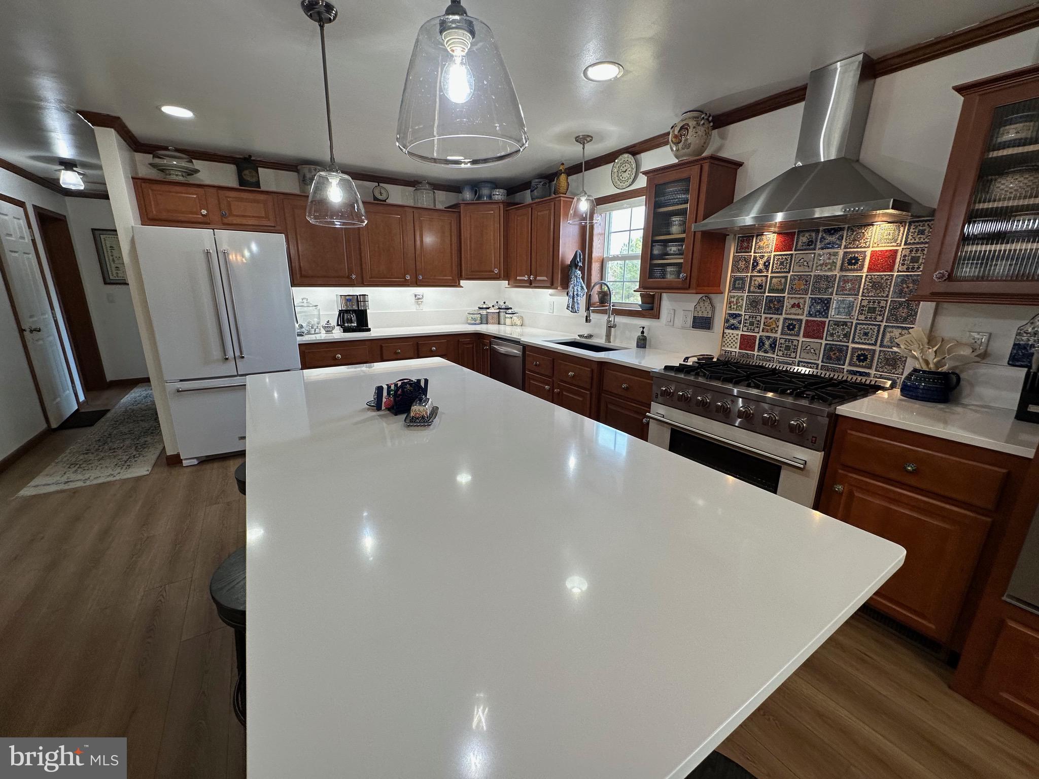 3402 Elk Lick Road Everett, PA 15537 - Photo 9 of 80 a kitchen with stainless steel appliances a stove a sink a refrigerator white cabinets and chairs