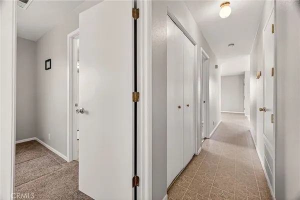 a view of a hallway with wooden floor and closet