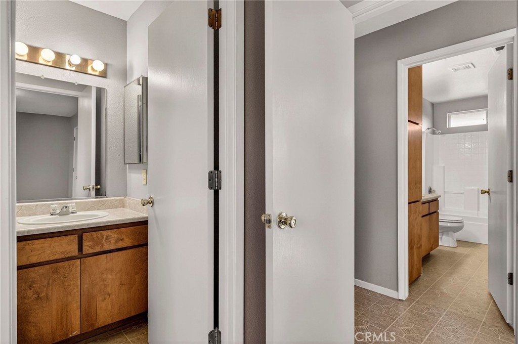 2883 5th Street Biggs, CA 95917 - Photo 22 of 38 a bathroom with a granite countertop sink and a mirror