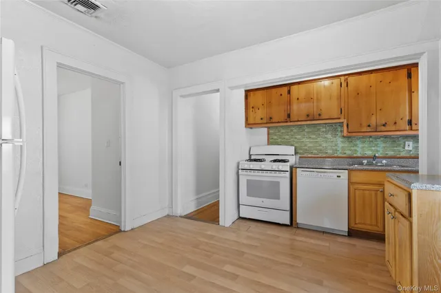 a kitchen with granite countertop white cabinets and white appliances