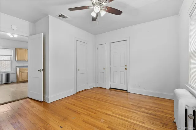a view of empty room with wooden floor
