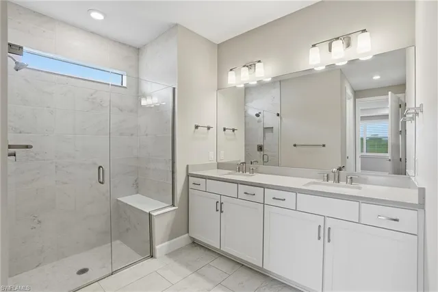 a bathroom with a double vanity sink mirror and shower