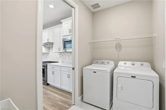 a view of washer and dryer with kitchen in the background