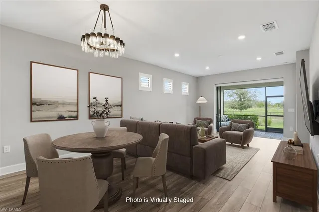a living room with furniture a chandelier and a table