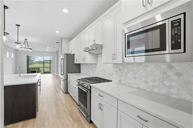 a kitchen with stainless steel appliances granite countertop a stove a sink and a refrigerator