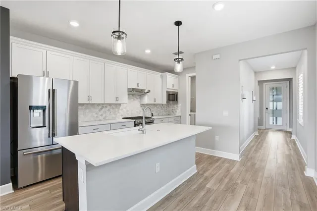a kitchen with kitchen island a sink stainless steel appliances and refrigerator