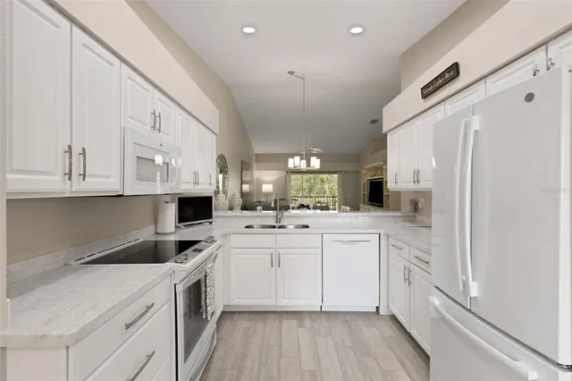 a view of a dining room with furniture a chandelier and wooden floor