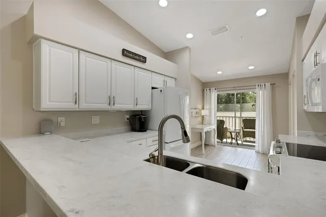 a living room with furniture and a large window with garden view