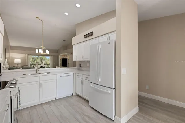 a kitchen with white cabinets and white appliances
