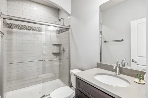 a bathroom with a granite countertop sink toilet and shower