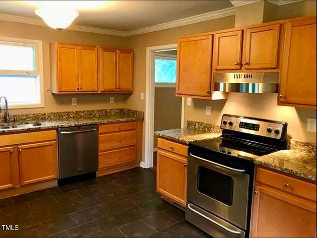 a kitchen with a stove a sink and a granite counter top
