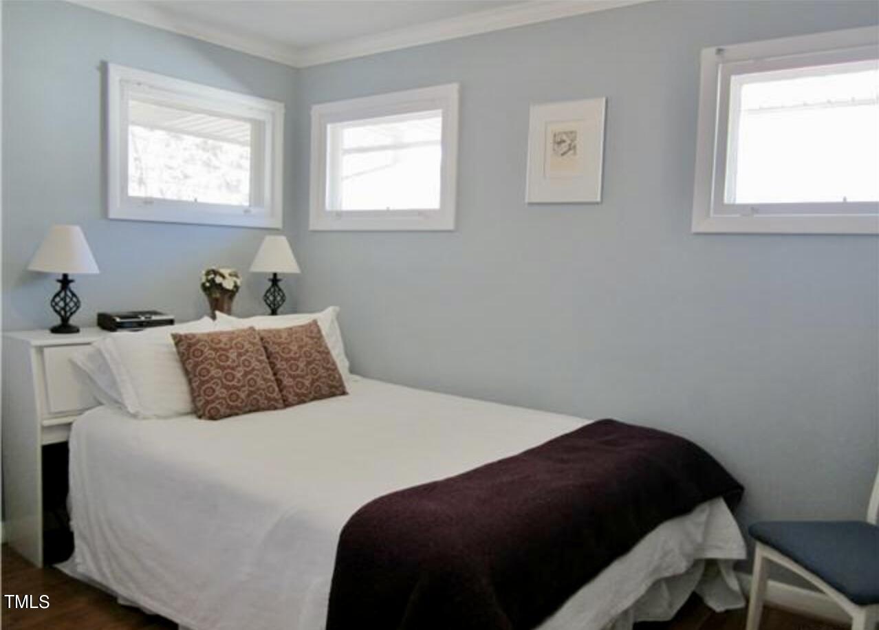 916 Dixie Trail Raleigh, NC 27607 - Photo 9 of 22 a bedroom with a bed two window and a lamp