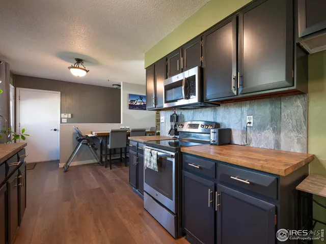 a kitchen with stainless steel appliances granite countertop wooden cabinets a stove top oven a sink and dishwasher