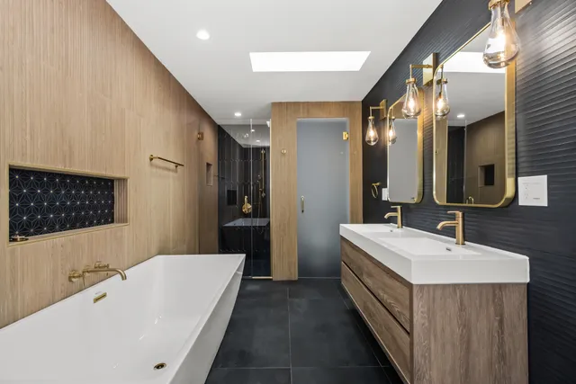 a bathroom with a double vanity sink a mirror and a bathtub