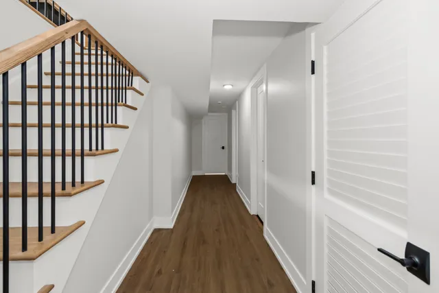 a view of a hallway with wooden floor and staircase
