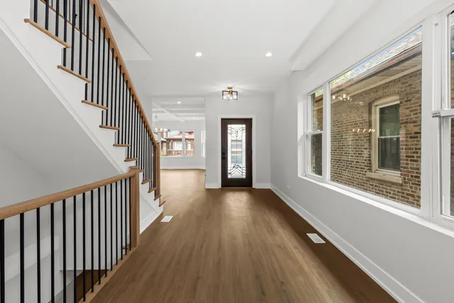 a view of a hallway with wooden floor and staircase