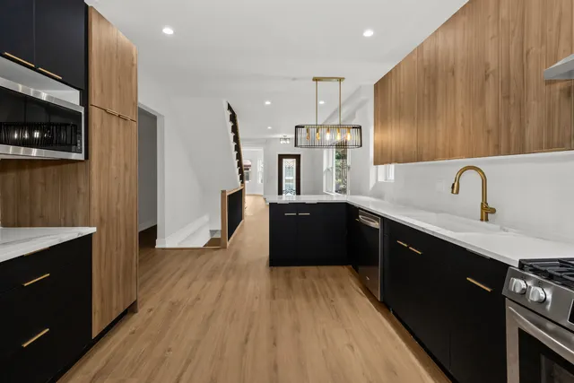 a kitchen with stainless steel appliances wooden floors wooden cabinets and sink