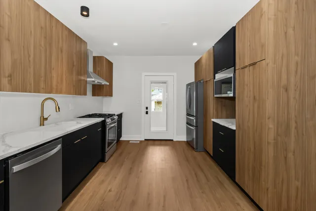 a kitchen with a sink a counter top space stainless steel appliances and cabinets
