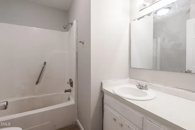 a bathroom with a granite countertop sink a mirror a vanity and a bathtub