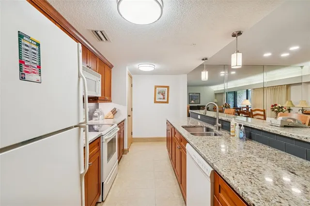 a kitchen with stainless steel appliances granite countertop sink stove refrigerator and cabinets