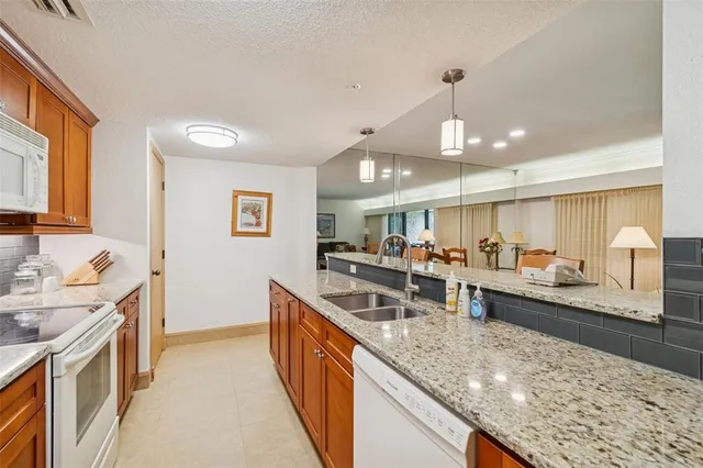 a large kitchen with stainless steel appliances granite countertop a lot of counter space and wooden floors