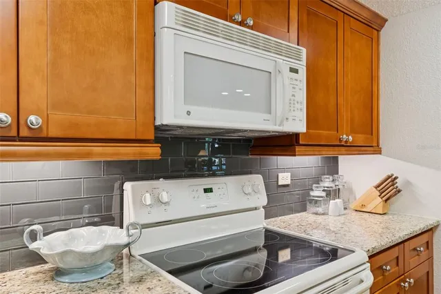 a view of a dining room with furniture one side kitchen view and wooden floor