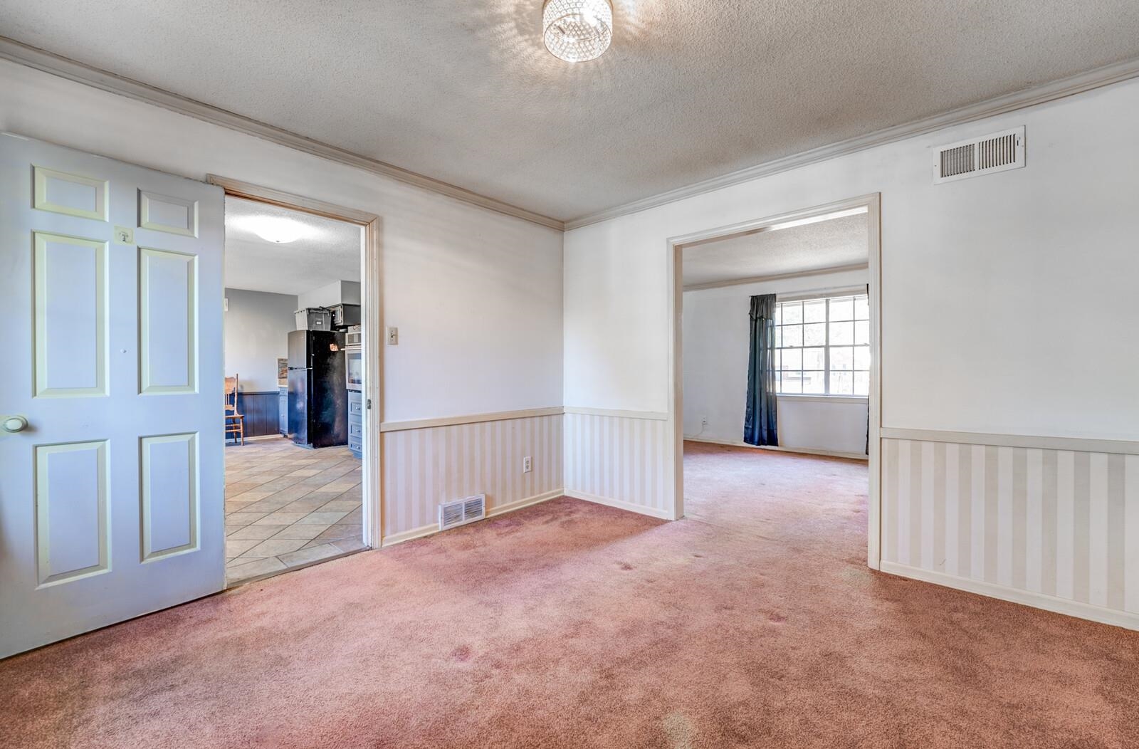 3241 Scheibler Road Memphis, TN 38128 - Photo 9 of 34 Empty room with a textured ceiling, carpet flooring, wainscoting, and crown molding
