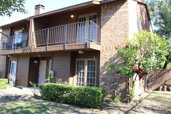a front view of a house with a tree