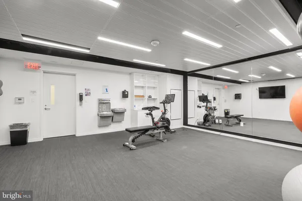 a room with gym equipment and mirror