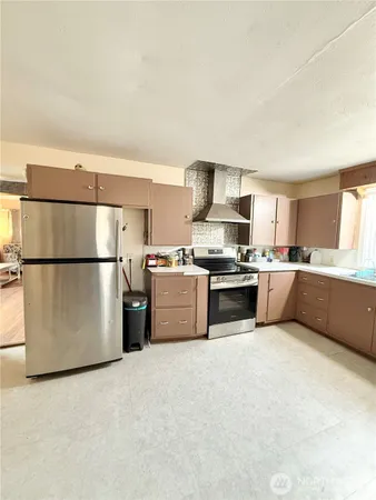 a large kitchen with stainless steel appliances granite countertop a large counter top and a stove