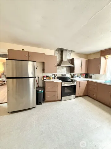 a large kitchen with stainless steel appliances granite countertop a large counter top and a stove