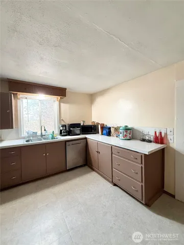 a living room with furniture a flat screen tv and a refrigerator