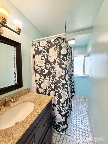 an empty room with ceiling fan and windows