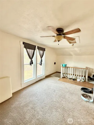 a view of a room with wooden floor and a ceiling fan