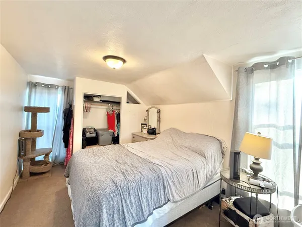 a bedroom with a bed and a large mirror with window