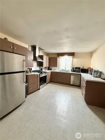 a kitchen with stainless steel appliances a refrigerator sink and cabinets