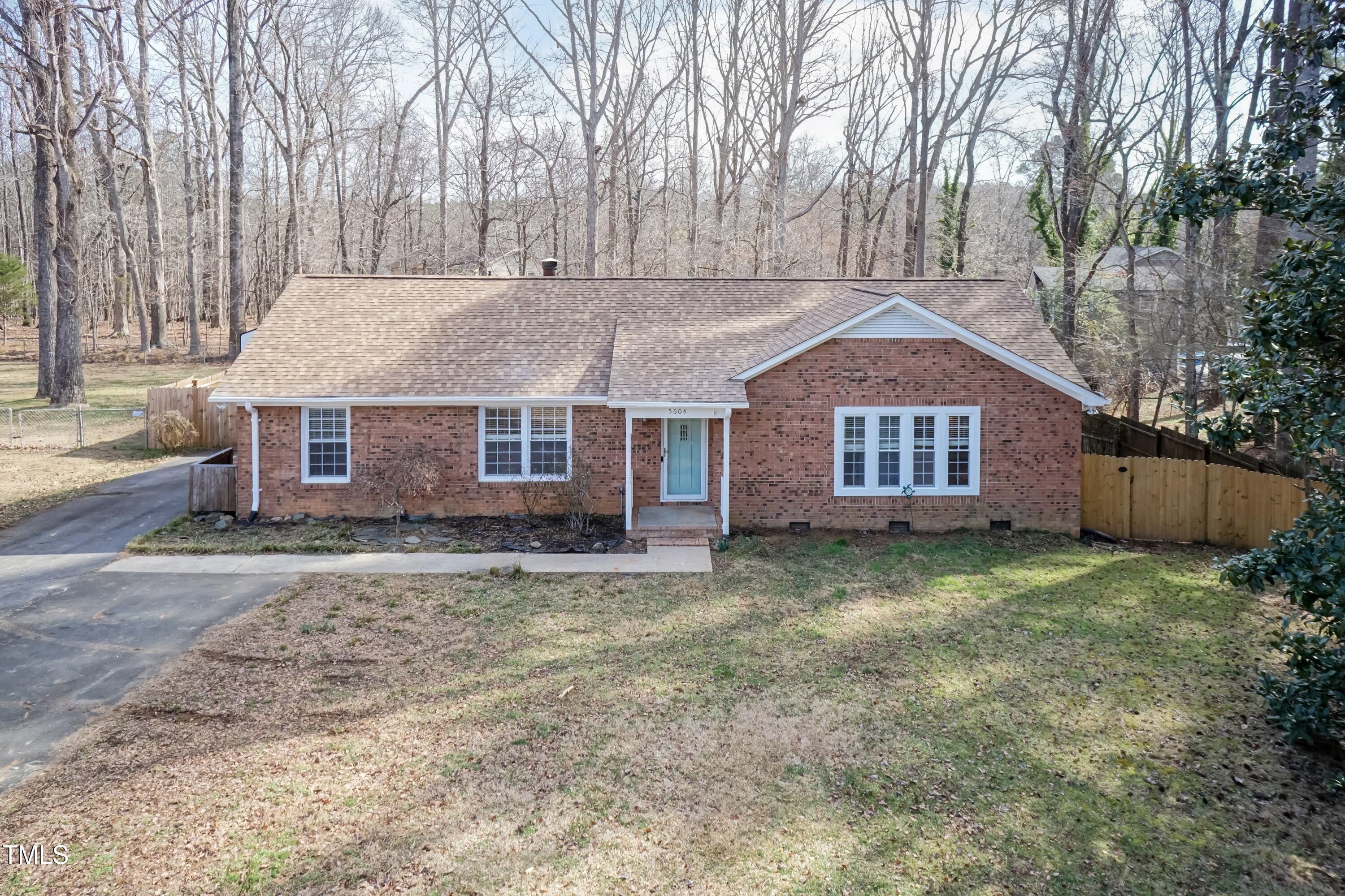 a view of a yard in front of a house with large trees