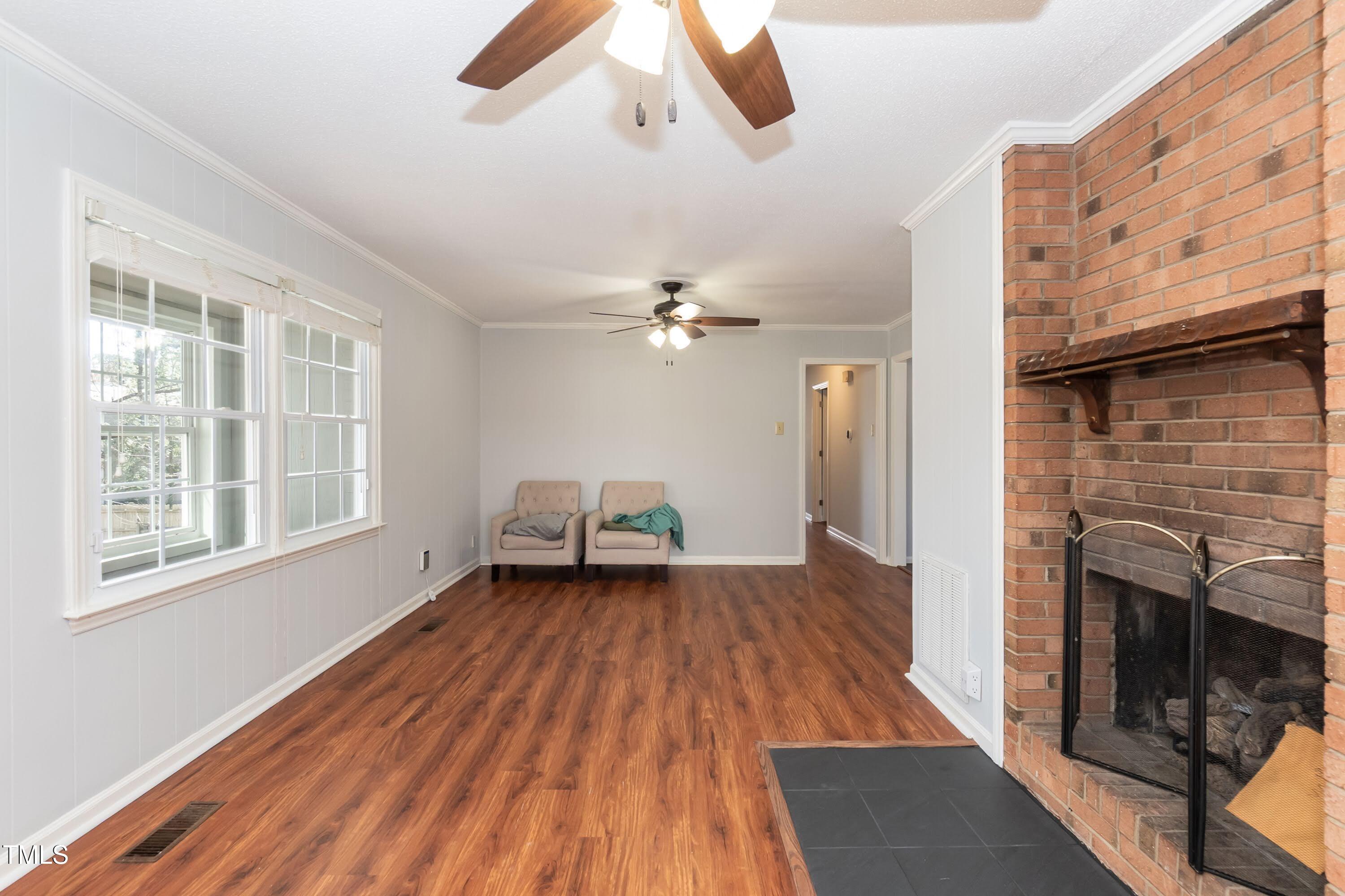 5604 Genesee Drive Durham, NC 27712 - Photo 11 of 45 wooden floor in an empty room with a fireplace and a window