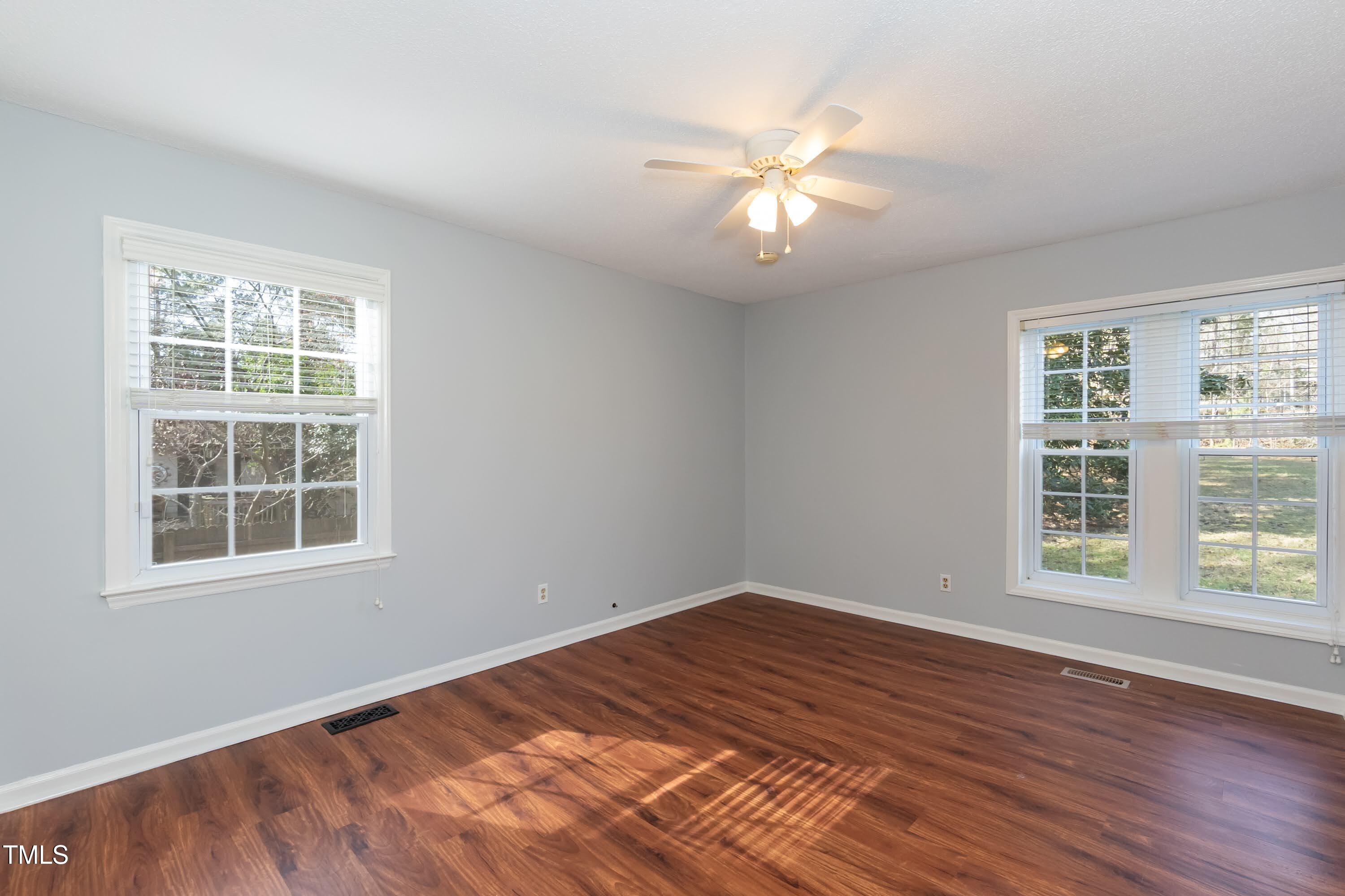 5604 Genesee Drive Durham, NC 27712 - Photo 17 of 45 an empty room with wooden floor windows and fan