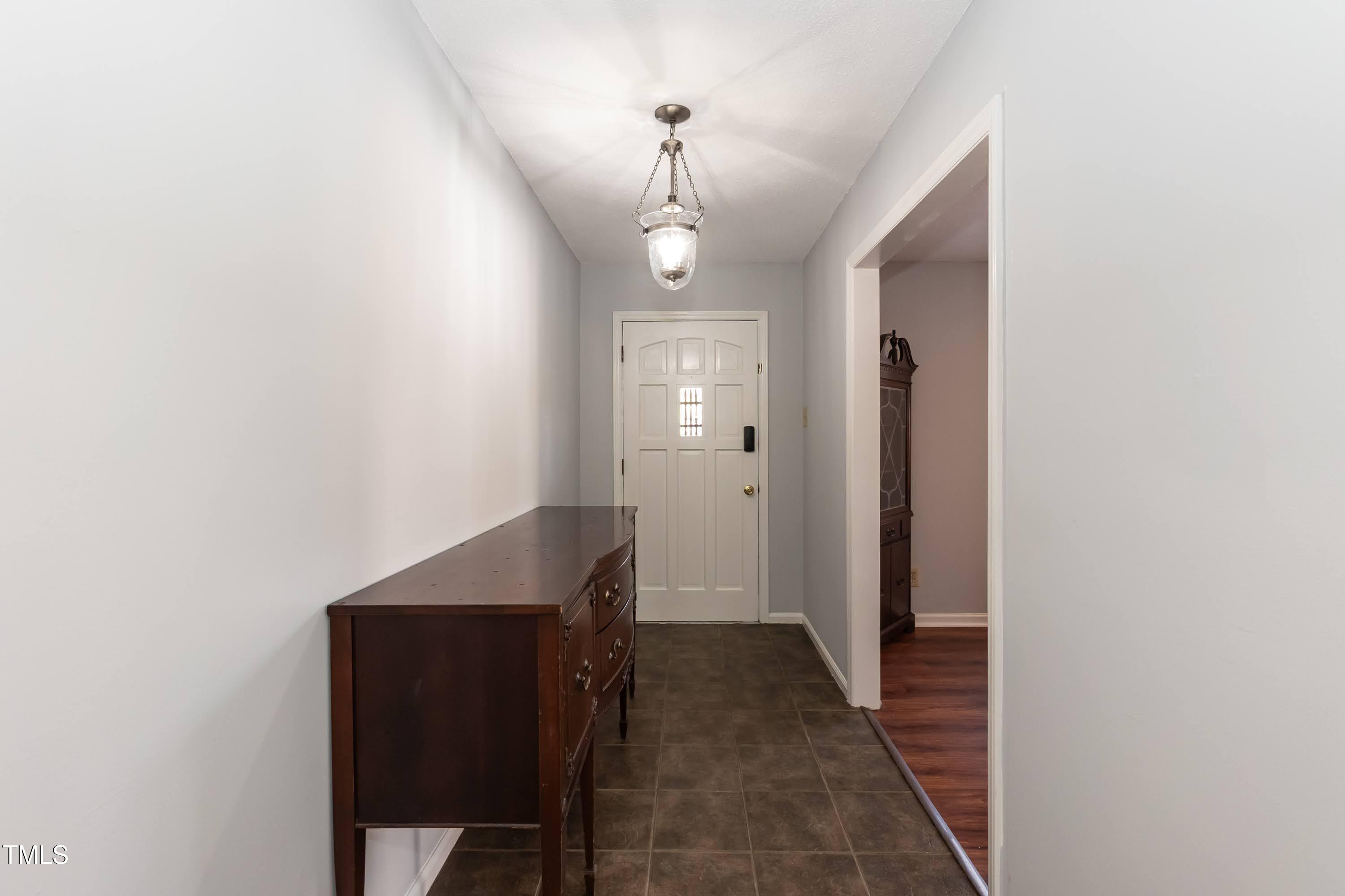5604 Genesee Drive Durham, NC 27712 - Photo 6 of 45 a hallway with front door wooden floor and windows