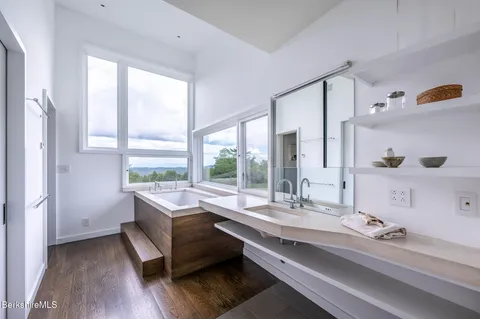a bathroom with a granite countertop toilet a sink and a large mirror