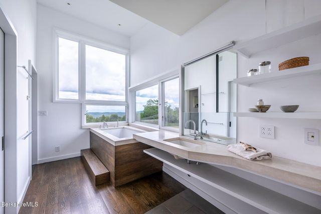 a bathroom with a granite countertop toilet a sink and a large mirror