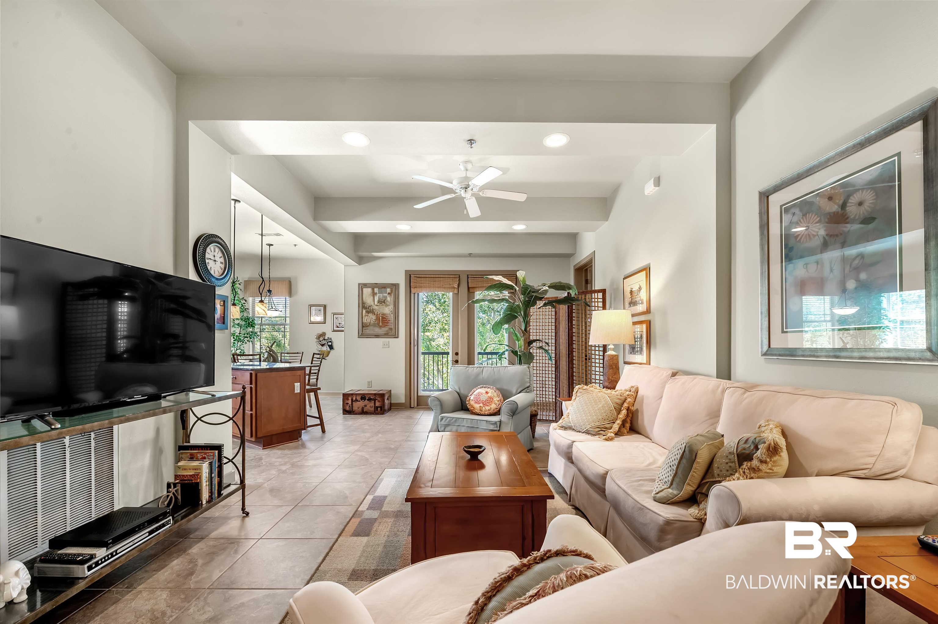 1430 Regency Road, Unit A301 Gulf Shores, AL 36542 - Photo 6 of 47 Tiled living room with beam ceiling and ceiling fan