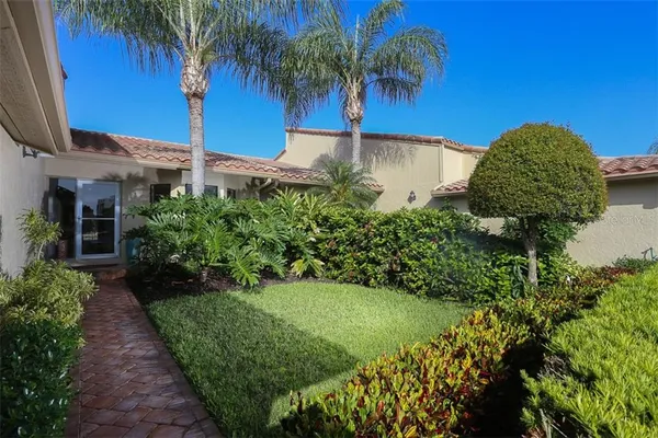a front view of a house with a yard and potted plants