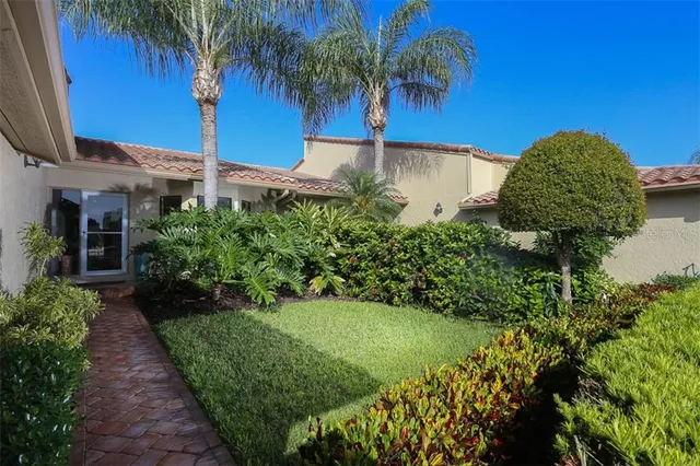 a front view of a house with a yard and potted plants