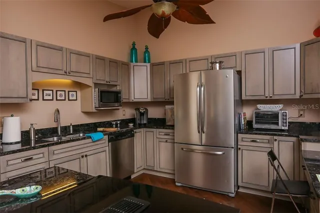 a kitchen with stainless steel appliances granite countertop a refrigerator stove top oven a sink and dishwasher